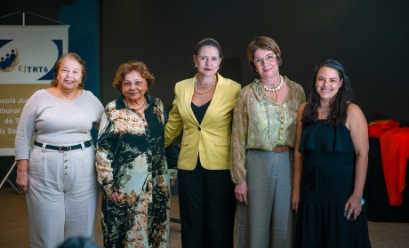 Na foto, cinco senhoras perfiladas no auditório da Ejud6