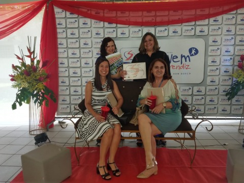 Fotografia de quatro servidoras com o certificado de parceria do Programa Jovem Aprendiz