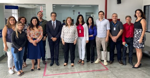 Foto da equipe da 3ª VT de Caruaru e também da Corregedoria. As pessoas estão em pé, na frente de uma porta de vidro