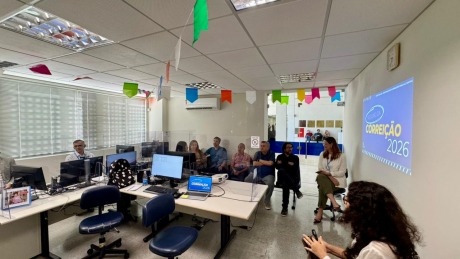 Na fotografia, aparece um grupo de adultos, reunidos numa sala de audiência