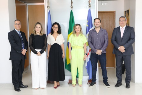 Retrato dos empossados, da presidente do TRT6 e de outros dois servidores. Eles posam junto às bandeiras do Brasil, Pernambuco e Recife 
