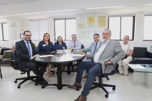 Sete pessoas estão sentadas em torno de mesa de reunião no gabinete da Vice-Presidência do TRT-6