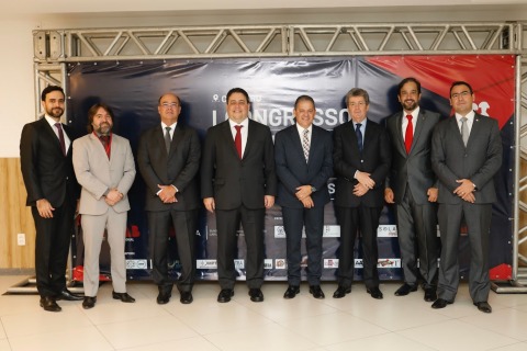 Fotografia de oito homens de terno, em pé, posando para a câmera