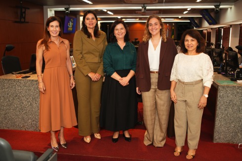 Foto mostra cinco mulheres em pé, lado a lado