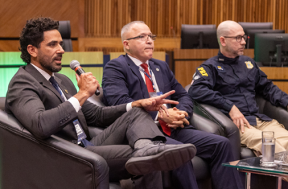 Na foto, três homens sentados participando de um Painel