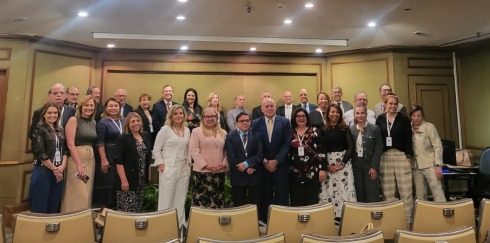 foto de várias autoridades em pé, posando para foto, dentro de um auditório