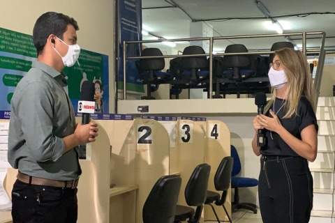 Fotografia da juíza e do repórter durante a entrevista. Ambos usam máscara e falam ao microfone