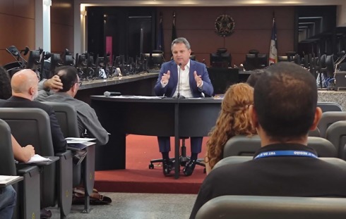 Foto do palestrante falando para o público na Sala de Sessões do Pleno