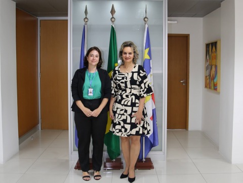 foto da servidora Raphaela Duarte e da desembargadora Nise Pedroso, em pé, em um escritório. Elas olham para a câmera e usam roupas de formais de trabalho