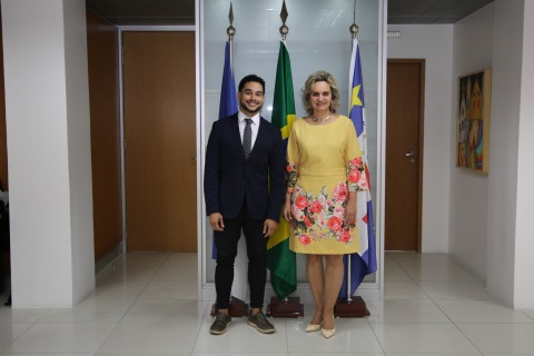 fotografia do analista Michael e da presidente Nise em pé, em uma sala de reuniões