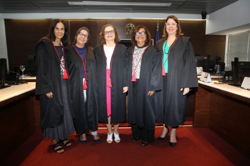 foto de cinco mulheres de toga, em um auditório