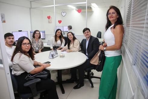 Fotografia de várias pessoas em uma uma mesa de reuniões