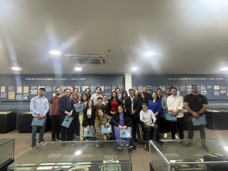 Fotografia onde aparece um grupo formado por 27 adultos perfilados no Memorial do TRT6