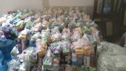 Foto de vários kits de higiene. São sacolas com sabonetes, água sanitária,álcool, sabão amarelo, etc.