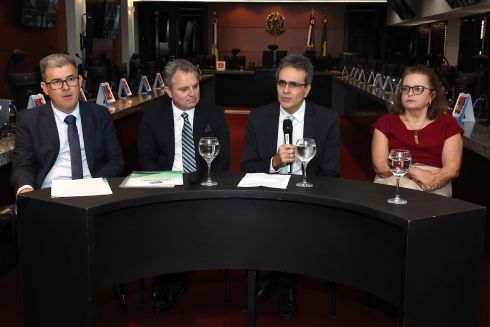 foto quatro pessoas sentadas em mesa de honra