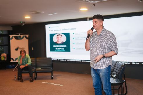 foto palestrante homem falando em pé ao microfone