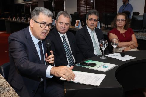 foto homem sentado falando ao microfone