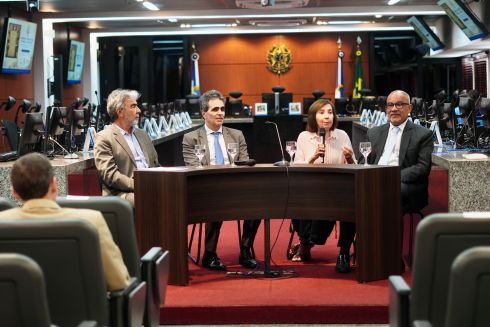 foto uma mulher e três homens sentados a mesa de honra