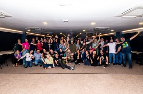 Fotografia onde aparece o grupo de todos os participantes do evento perfilados no auditório da Escola Judicial