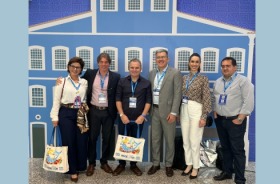 Fotografia onde aparecem perfilados, de pé, uma mulher e cinco homens