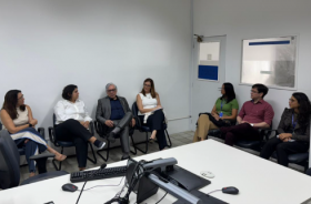 Fotografia onde aparecem sete adultos sentados numa sala de audiência