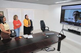 Solenidade de posse, onde aparecem três mulheres perfiladas e um senhor participando de forma virtual