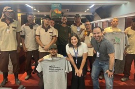foto participantes do evento em pé posando para registro na sala de sessões