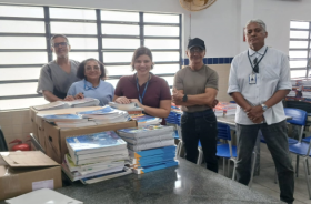 foto pessoas em sala de aula; livros sobre uma mesa