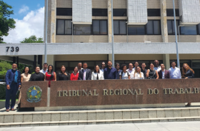 foto pessoas em pé em frente ao prédio do tribunal