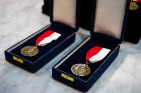 Foto mostra duas medalhas de bronze, dentro de estojos de veludo azul marinho