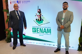 Na fotografia aparecem dois homens perfilados no meio do painel do 6º ENAM