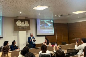 Na imagem, um homem de pé, palestrando no auditório da OAB PE