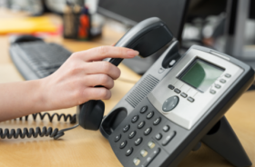 Imagem de pessoa utilizando telefone fixo