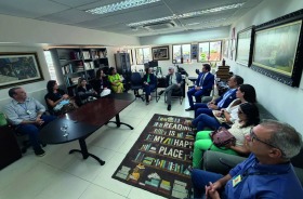 Na foto, aparecem 12 adultos sentados no gabinete da Corregedoria do TRT6