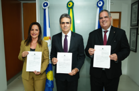 Foto de quem assinou o acordo segurando o termo