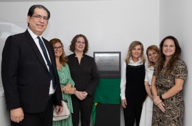 Fotografia onde aparecem seis adultos perfilados ao lado de uma placa inaugural da 24ª Vara do Trabalho