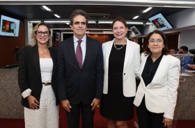 Fotografia onde aparecem três mulheres e um homem perfilados na Sala do Pleno