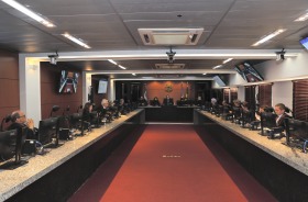 foto da sessão do Tribunal Pleno: sala ampla com grande mesa em U e pessoas de toga sentadas