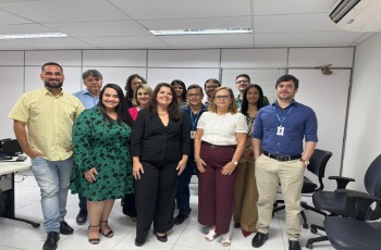 Fotografia onde aparece um grupo formado por homens e mulheres, perfilados numa sala de audiências