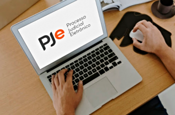 Imagem de pessoa usando notebook com logo e texto: "PJe processo Judicial Eletrônico"