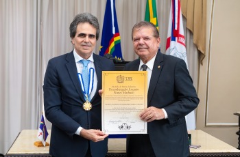 Fotografia onde aparecem dois senhores segurando um diploma