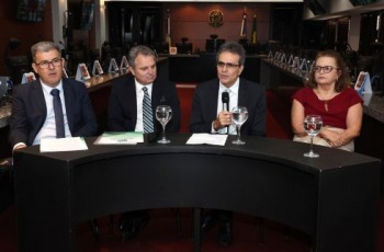 quatro pessoas sentadas em mesa de honra