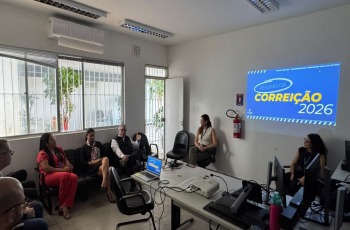 Na foto, aparecem oito adultos sentados na sala de audiências de uma Vara