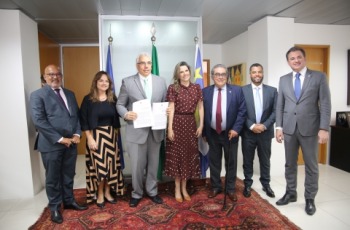 Fotografia onde aparece um grupo de sete adultos, perfilados no Gabinete da Presidência do TRT-6