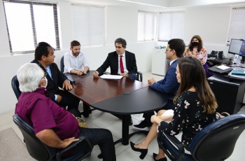 foto pessoas sentadas reunidas em volta da mesa